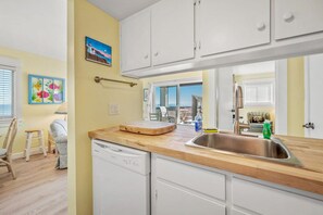 A kitchen with white cabinets, a wooden countertop, and a stainless steel sink. - Best Views in Sand Dollar! Beachfront w/ Pool (Fernandina Beach)