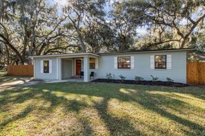 A single-story house with a front porch, a small front yard, and a wooden fence. - 30+ Day Coastal Cottage Near Downtown (Fernandina Beach)