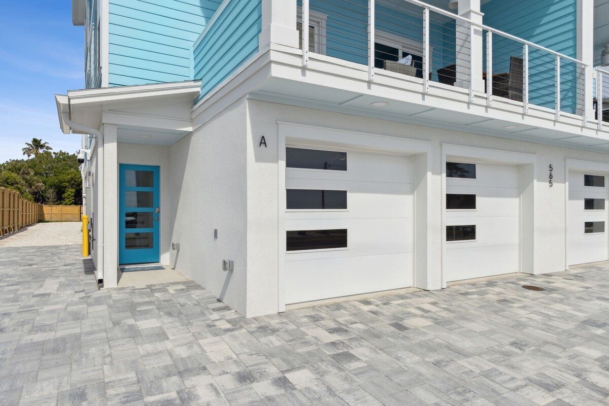 A two-story building with a blue exterior, white garage doors, and a visible garage number.