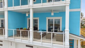 A multi-level building with balconies, railings, and a covered outdoor seating area. - Brand New 4BR • Ocean Views • Pool (Fernandina Beach)
