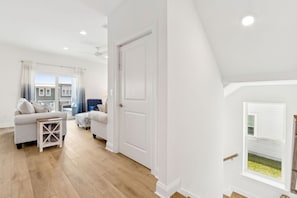 A spacious living area with a sofa, coffee table, and a door leading to another room. - New Oceanfront Amelia Island Beach Estate with Private Pool and Two Elevators (Fernandina Beach)