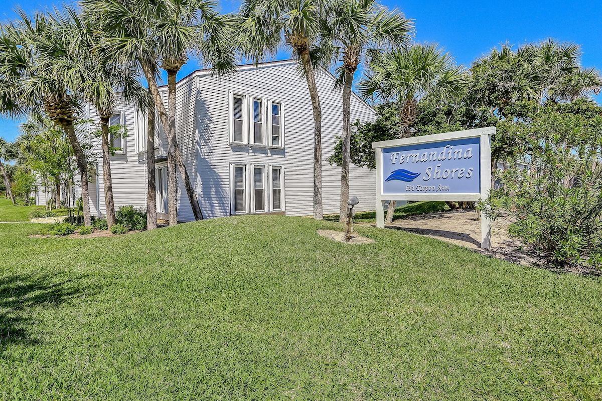 A two-story building with a sign reading 'Fernandina Shores.'
