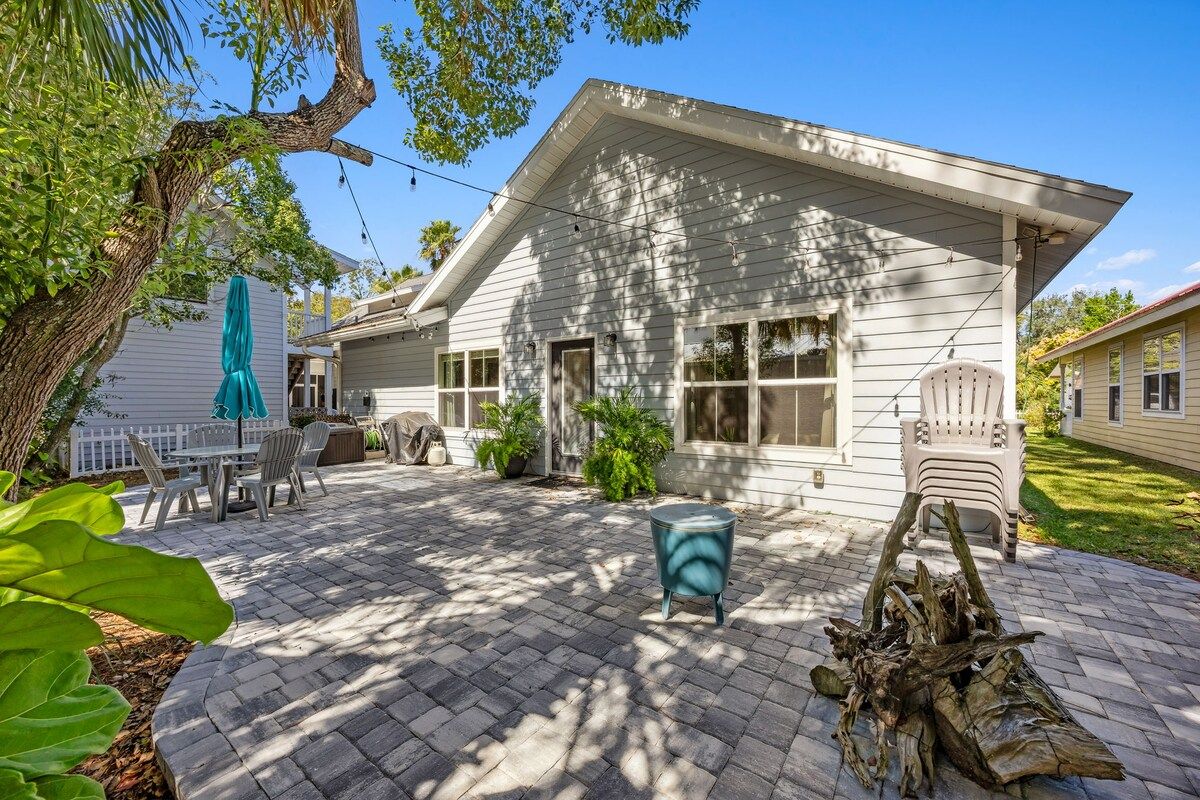 A house with a patio, outdoor furniture, and a tree.