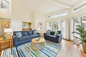 Ein geräumiges Wohnzimmer mit zwei Sofas, einem Couchtisch und einem großen Fenster, das für natürliches Licht sorgt.