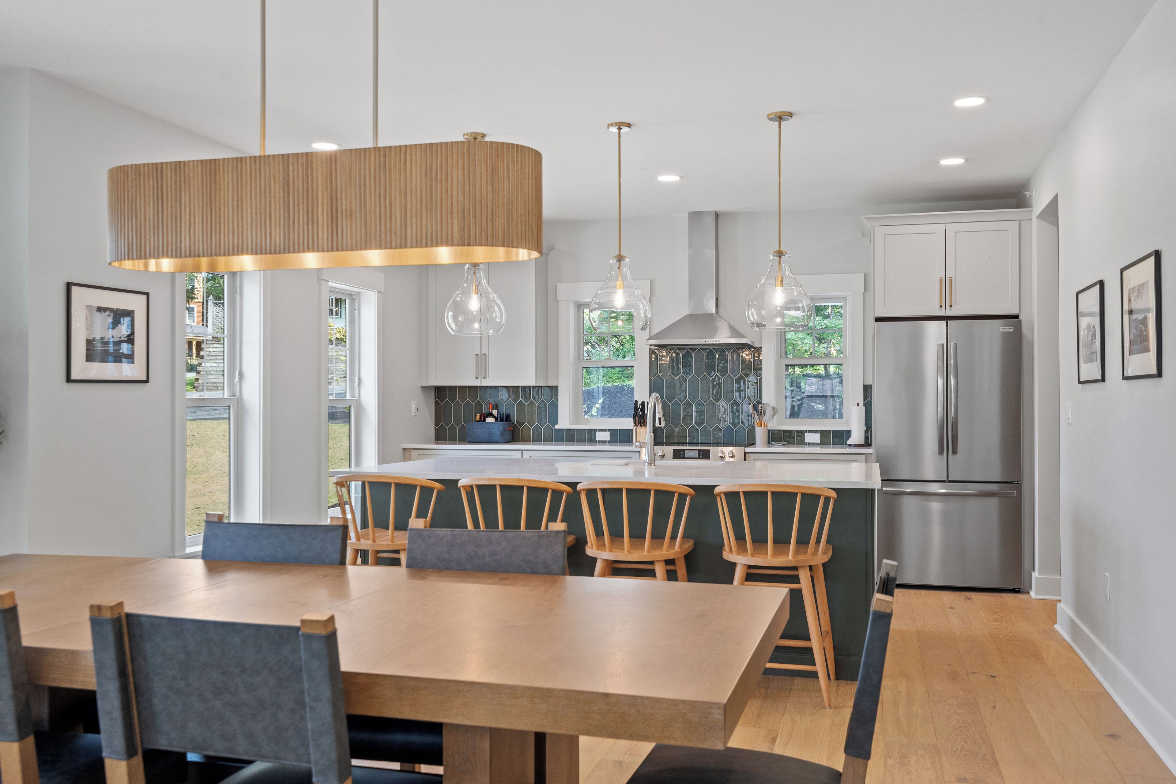 A modern kitchen with a central island, stainless steel appliances, and pendant lighting.