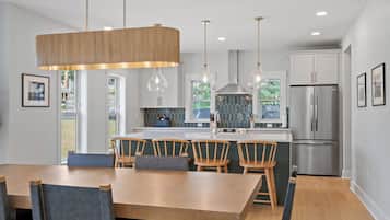 A modern kitchen with a central island, stainless steel appliances, and pendant lighting.