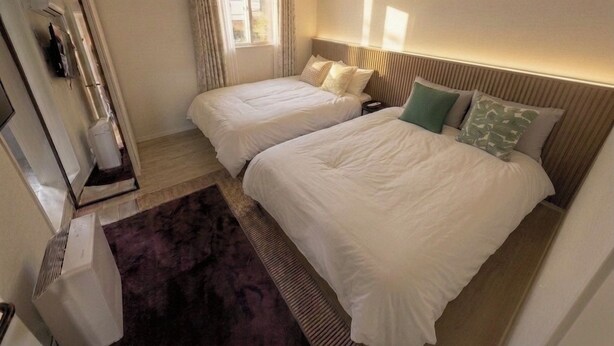 A hotel room with two beds, a window, a radiator, and a mirror. - Stay on you Gwangmyeong Station (Gwangmyeong)