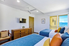 A hotel room with two beds, a wooden dresser, a television, and a balcony with a view. - Beachfront-2 BR Plus 2 BR-Apartment Shared Balcony (Puerto Vallarta)