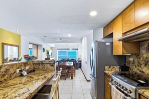 Una cucina con ripiani in granito, un frigorifero in acciaio inox e una cucina a gas.