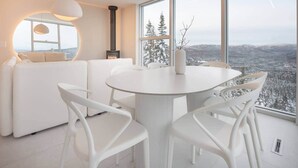 Een modern interieur met een ronde eettafel, witte stoelen en een bank.