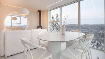 A modern interior with a round dining table, white chairs, and a sofa.