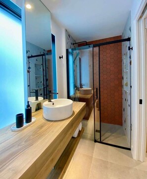 A modern bathroom with a round sink, a mirror, and a glass shower enclosure. - MIST / Micro-Chalet / Nature Immersion (Capitale-Nationale)