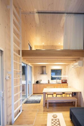 Ein modernes Interieur mit Holzboden, einem Esstisch und einer Bank.