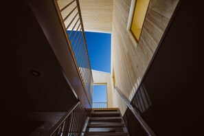 A staircase leading to an upper floor with a clear view of the sky through a skylight.