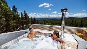 Boblebad på en terrasse med udsigt til skov og bjerge.