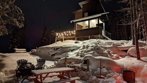 A snow-covered outdoor area with a wooden deck, a picnic table, and chairs. - MIR / Micro-Chalet / Panoramic View (Capitale-Nationale)