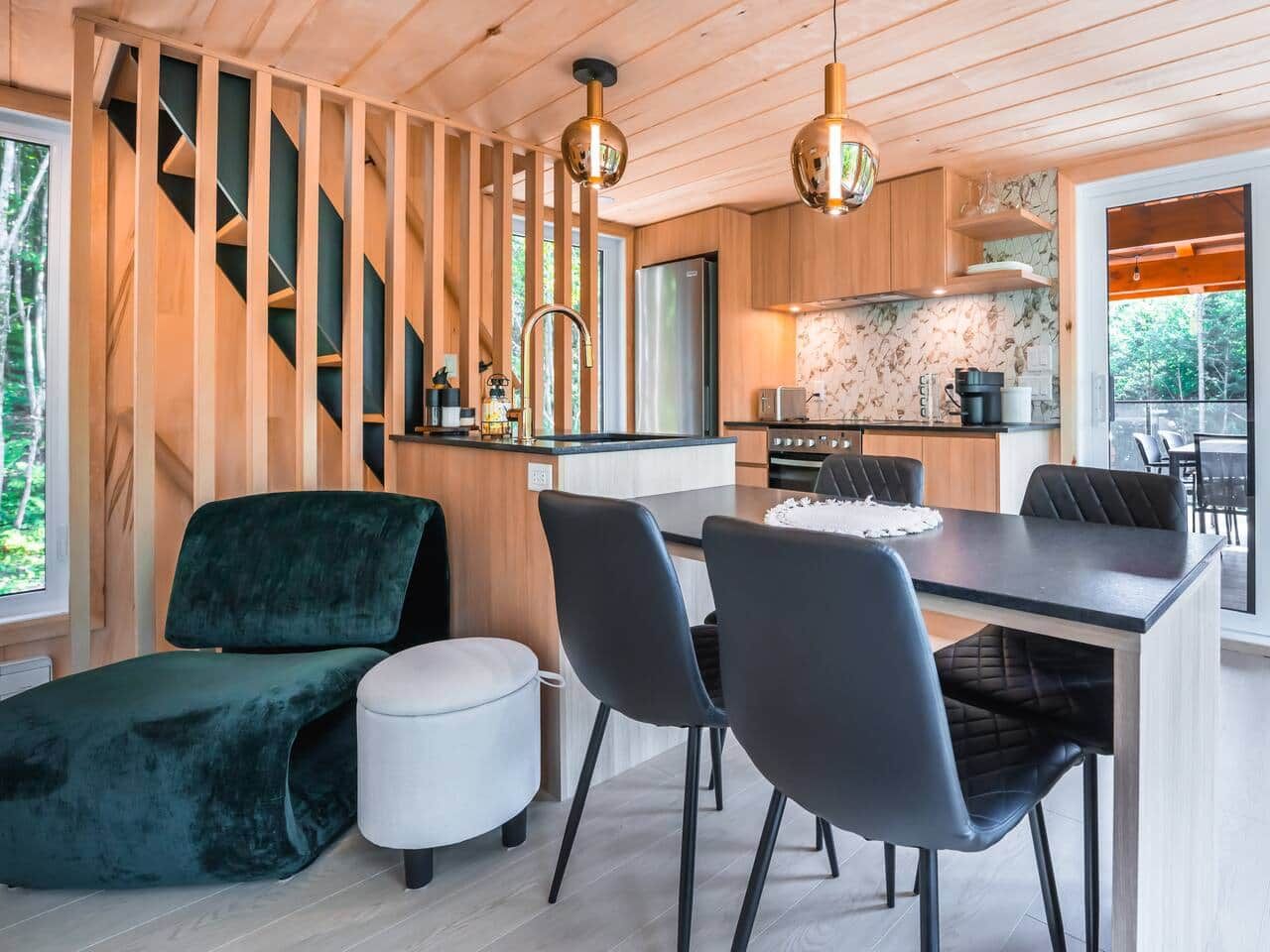 A modern kitchen with a central island, wooden cabinetry, and a stainless steel refrigerator.