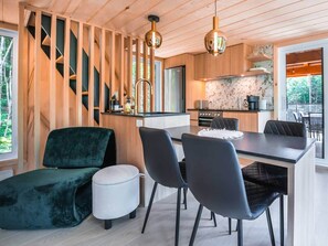A modern kitchen with a central island, wooden cabinetry, and a stainless steel refrigerator.