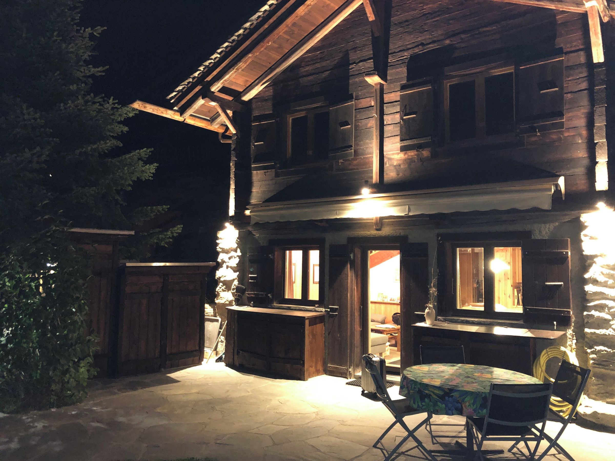 Eine Holzhütte mit einer Terrasse, komplett mit Tisch und Stühlen.