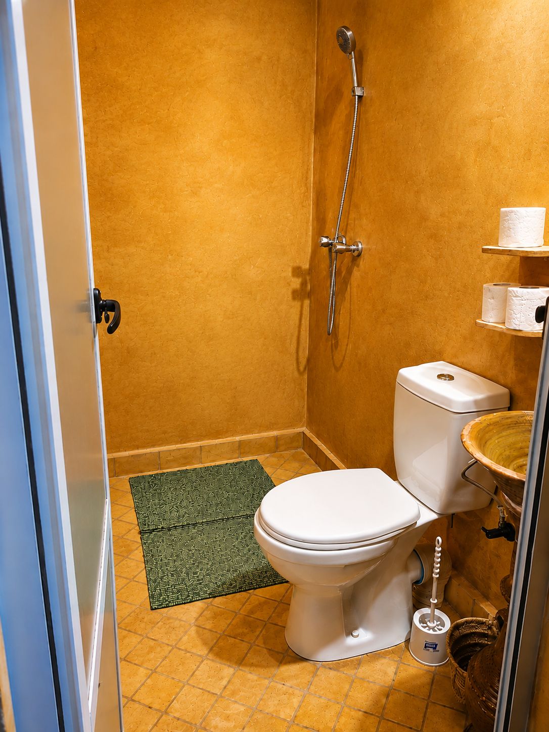 A bathroom with a toilet, a shower, and a sink.