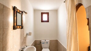 A small bathroom with a toilet, sink, and a window. - Riad Kasbah des Roches (Drâa-Tafilalet)