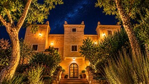 A building with a central entrance, stone steps, and a starry night sky. - Riad Kasbah des Roches (Drâa-Tafilalet)