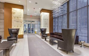 Un hall d’entrée avec un comptoir de réception, un espace salon et une grande fenêtre offrant une vue dégagée.