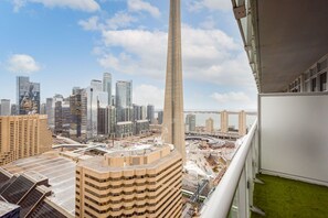Un immeuble de grande hauteur offrant une vue sur le paysage urbain, avec d’autres bâtiments imposants et une rivière.
