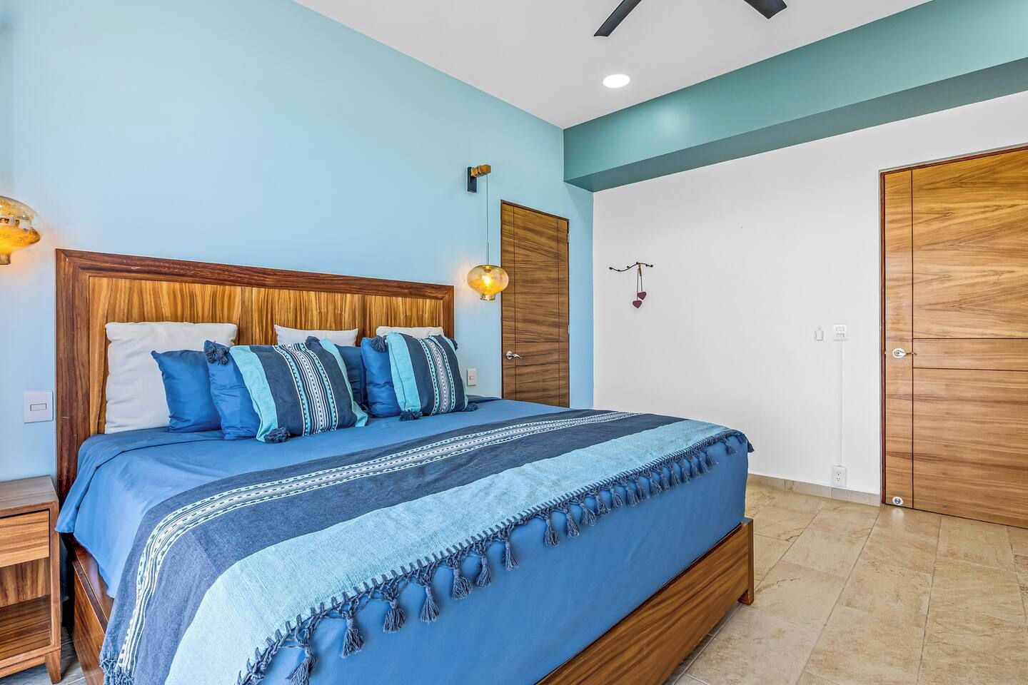 Une chambre à coucher avec un lit, une tête de lit en bois et une table de chevet.