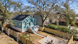 Una propiedad residencial con una casa azul, una valla de madera y un patio de grava.