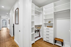A walk-in closet with open shelving, a hanging rod, and a small bench. - Luxury Old Town Retreat | Walk to Town Lift & Main Street | Private Hot Tub (Park City)