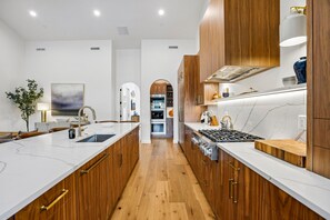 A modern kitchen with wooden cabinets, white countertops, and stainless steel appliances. - Luxury Old Town Retreat | Walk to Town Lift & Main Street | Private Hot Tub (Park City)