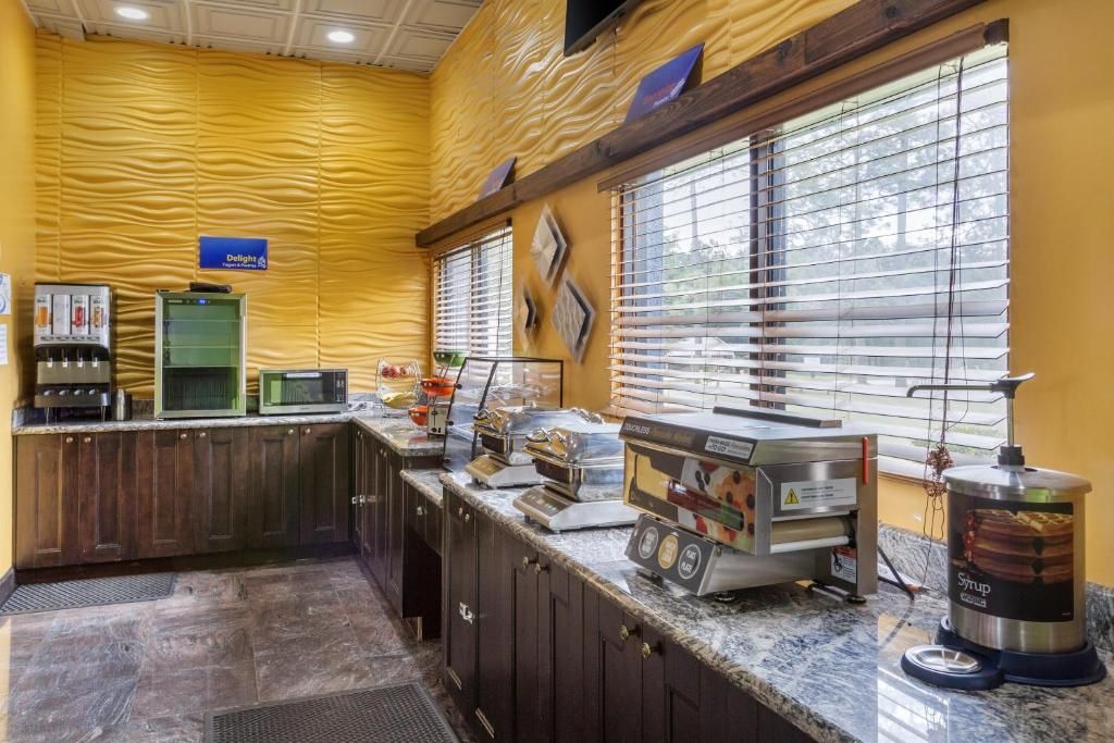 A kitchen area with a coffee machine, a syrup dispenser, and a microwave.