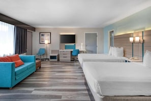 Habitación de hotel con una cama grande, un sofá, un escritorio y una silla.