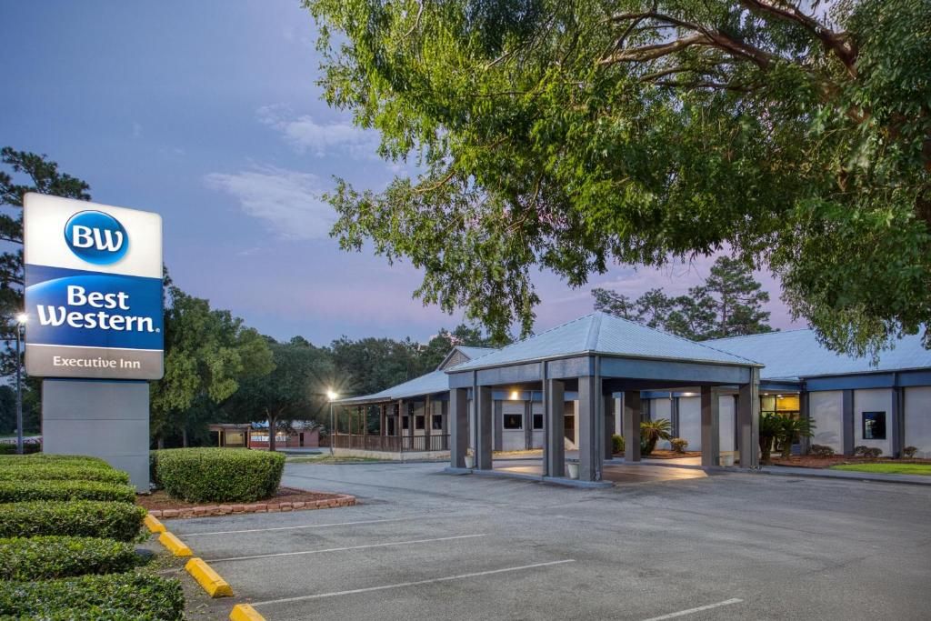 A Best Western Executive Inn with a covered outdoor area and a parking lot.