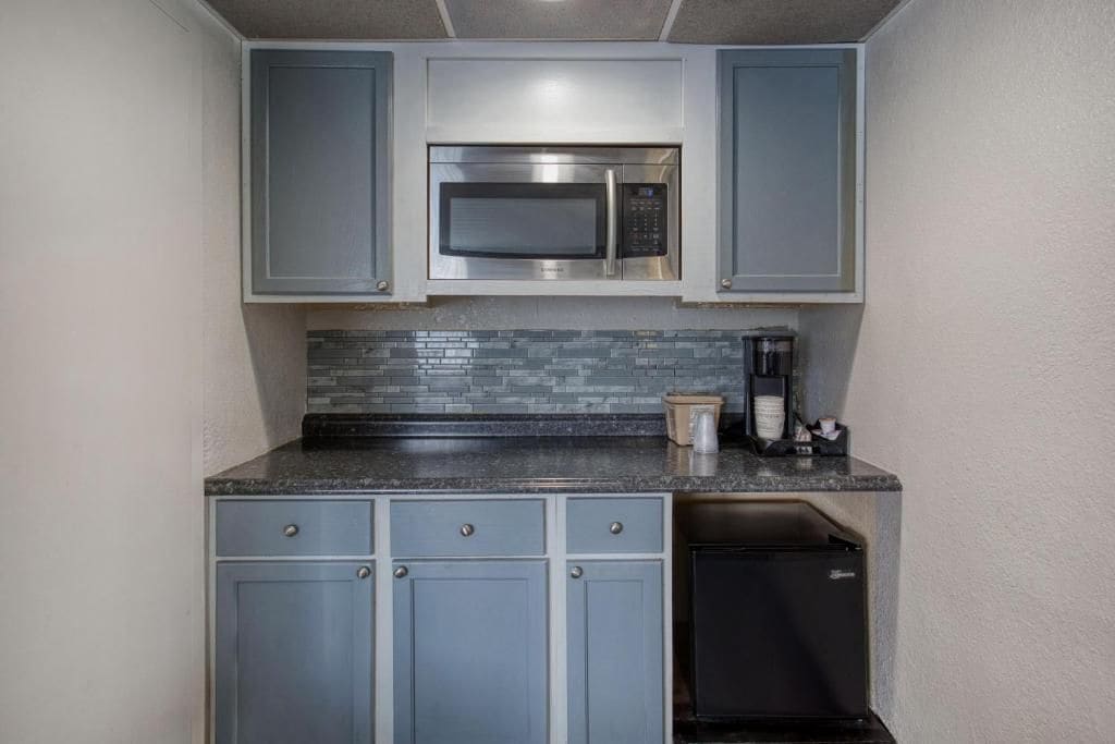 Una cocina compacta equipada con microondas, cafetera y lavavajillas.