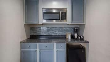 Una cocina compacta equipada con microondas, cafetera y lavavajillas.