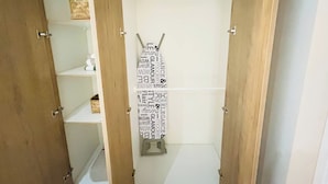 A closet with open doors, revealing shelves and hanging space. - 2BR/2B Suite, A/C and heating, Parking (Estación Central)