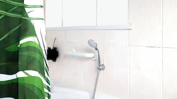 Ein Badezimmer mit Badewanne, Dusche, Fenster und Vorhang.