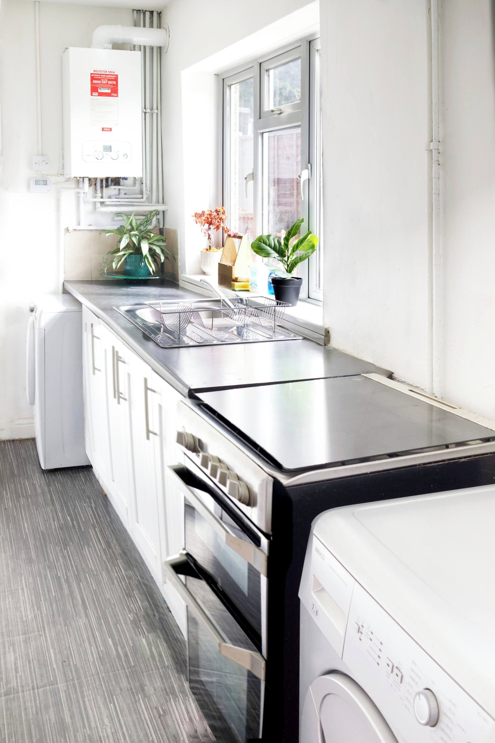 A modern kitchen with a built-in oven, a dishwasher, and a window with a view.
