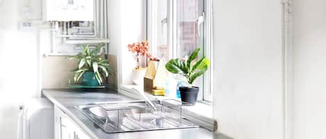 A modern kitchen with a built-in oven, a dishwasher, and a window with a view.