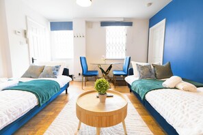 A hotel room with two beds, a round wooden table, and a small potted plant. - 2/3 Bedroom Duplex House, 2-minute walk from Camden Town tube Station, Sleeps 6 (London)
