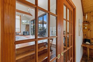 A wooden interior with a large sliding glass door leading to an outdoor deck. - Villa Annick | Affordable Waterfront Retreat in Oyster Bay I (Chincoteague Island)