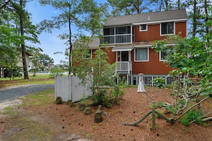 A two-story residential building with a visible balcony on the second floor. - Villa Annick | Affordable Waterfront Retreat in Oyster Bay I (Chincoteague Island)