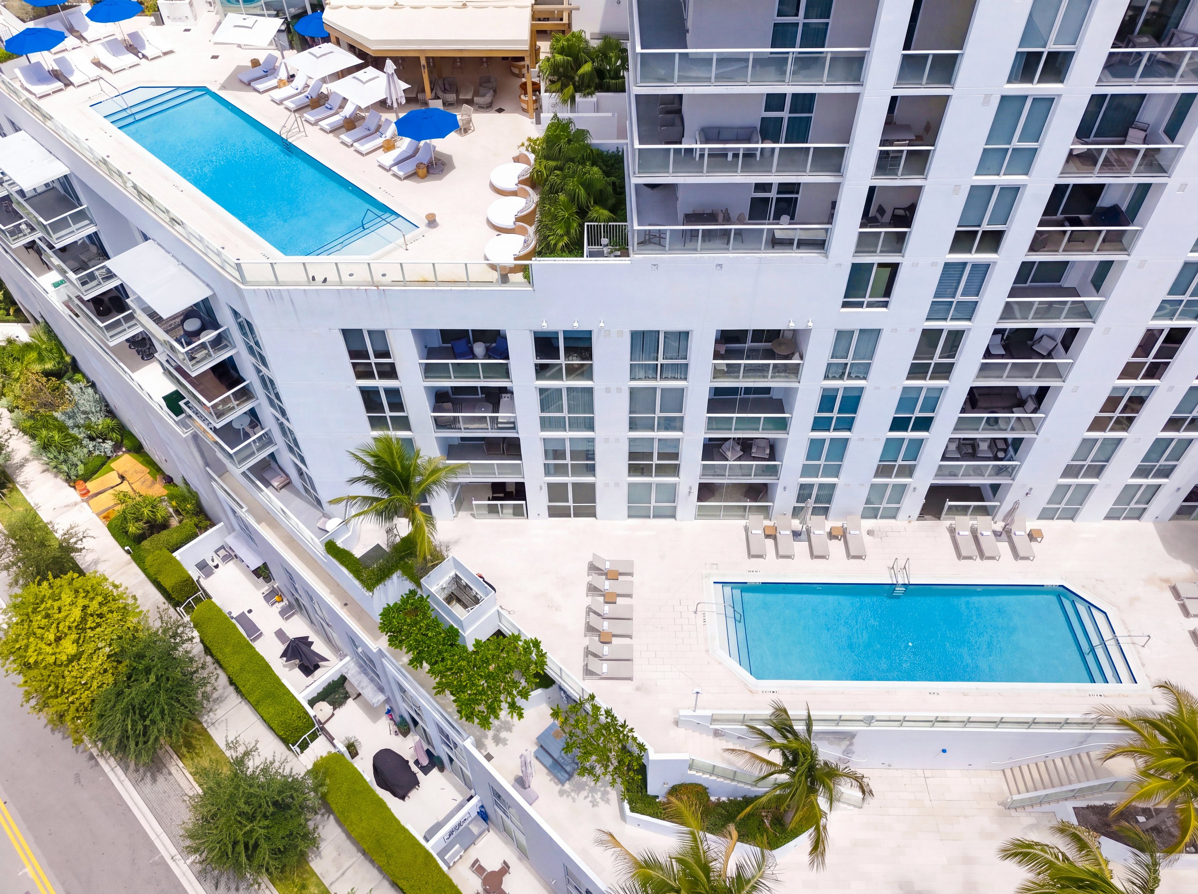Un hôtel à plusieurs étages doté d’une piscine sur le toit, d’un espace de détente en plein air et d’une grande piscine.