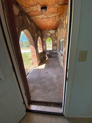 An interior corridor with stone arches, a concrete floor, and a view of the outdoors.
