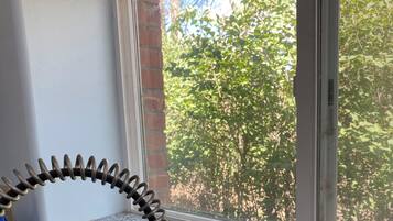 Una cocina con encimeras de granito, un grifo de acero inoxidable y ventana con vista a la vegetación.