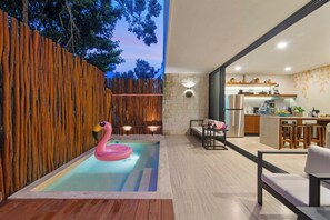 A modern outdoor living space with a pool, wooden fence, and a kitchen area. - Calakmul: Intimate 2BR w/ Private Plunge (Tulum)