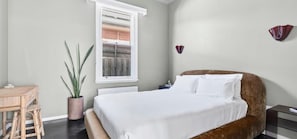 A bedroom with a bed, bedside table, lamp, potted plant, and a window. - Modern Heritage Retreat – walk to Pako & Waterfront (Greater Geelong)