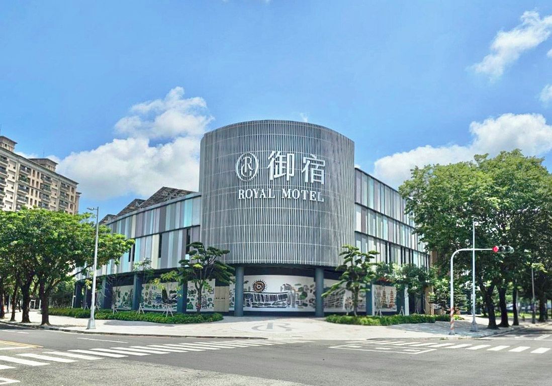 A modern hotel with a curved facade and a prominent sign.